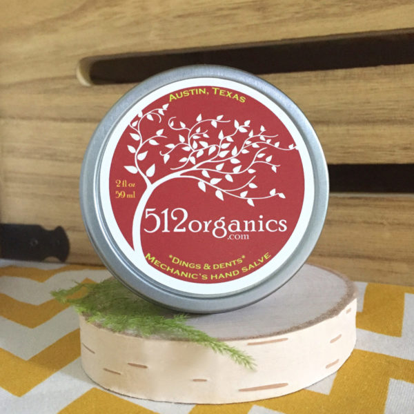 512organics tin of Dings & Dents hand salve with wood background and fern