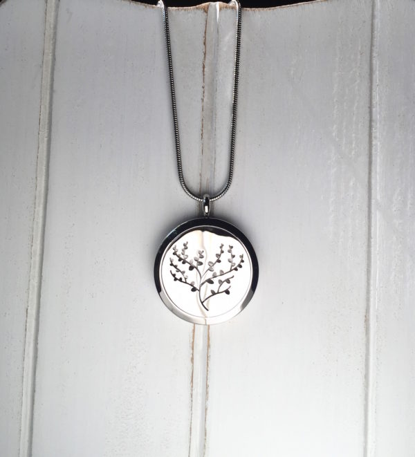 512organics essential oil diffusing necklace tree of life on white wood background