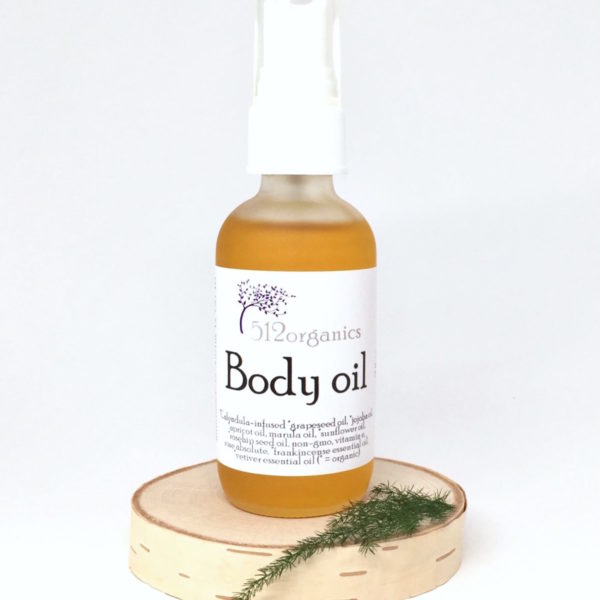512organics body oil on wood slice with fern